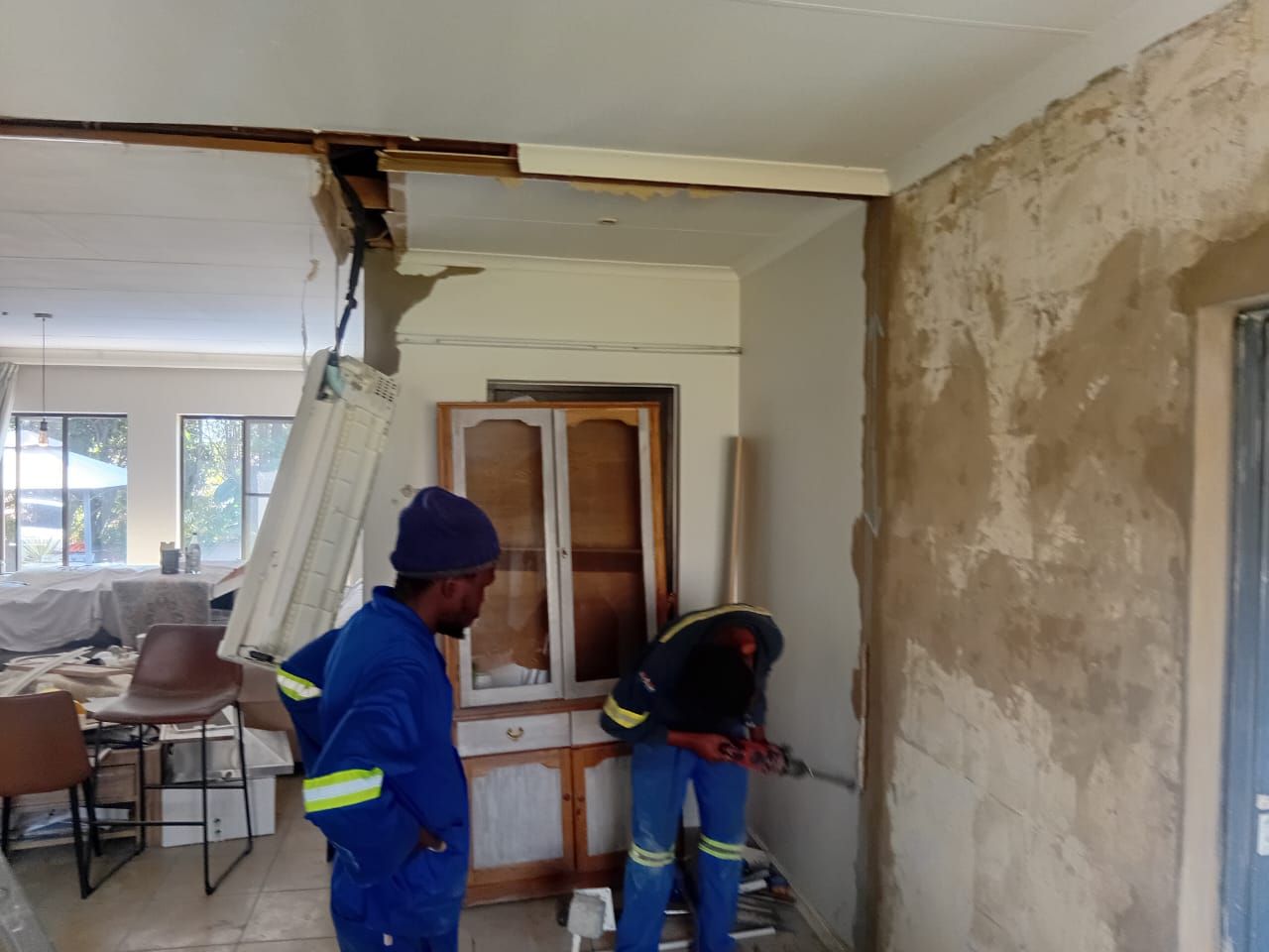 Dewasa team in blue workwear preparing a room for renovation